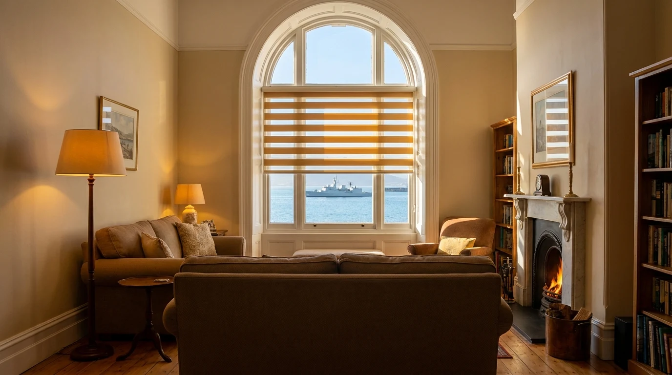 Day/night zebra blind in a Simon's Town heritage lounge with a naval vessel visible through the arched window